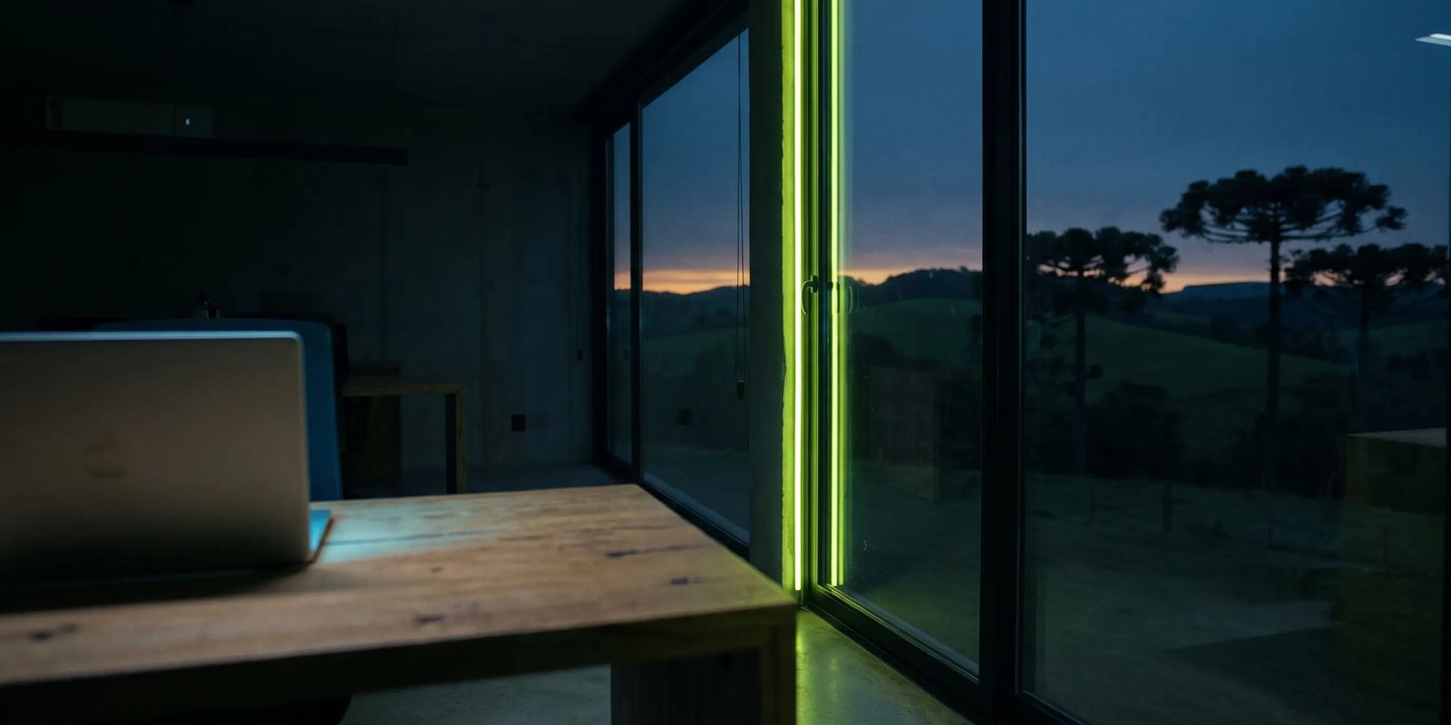 Escritório de agência de marketing digital com vista para araucárias no interior do Paraná ao entardecer